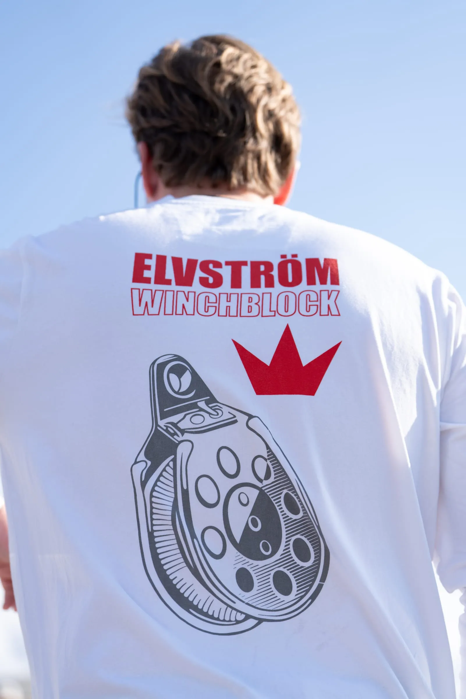 Ryggen af en hvid longsleeve med Elvstrøm Winchblock-tryk